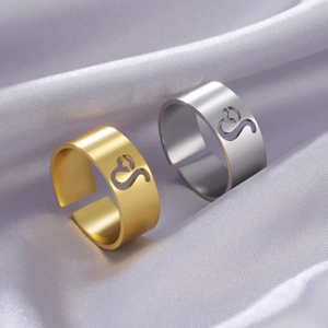 Detailed view of gold and silver Leo zodiac open rings on purple satin background