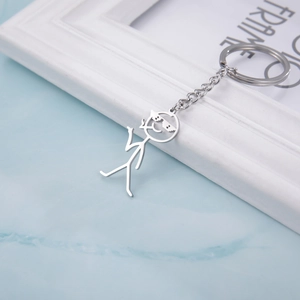 Polished silver metal keychain with a funny stick figure wearing pixel sunglasses on marble