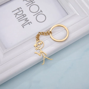 Detailed view of a gold stickman pendant with sunglasses on a circular metal keyring