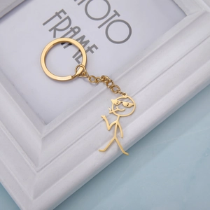 Close-up of golden stainless steel keychain featuring a stylish sunglasses boy pendant