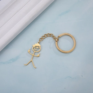 Detailopname van een grappige goudkleurige stokfiguur sleutelhanger met middelvinger