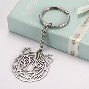 Detailed macro view of silver geometric tiger head keychain on a mint green gift box