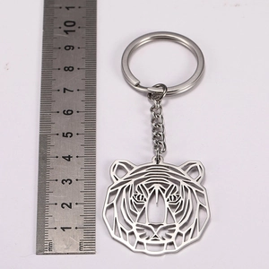 Detailed scale view of a stainless steel geometric tiger head keychain with ruler measurement