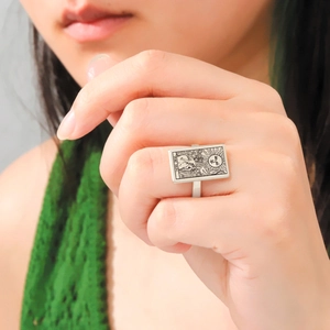 Detailed close-up of tarot Sun XIX card engraving on a vintage silver stainless steel ring