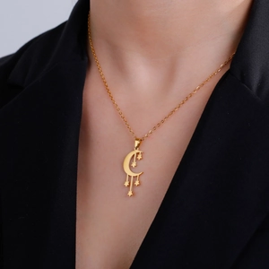 Collar dorado con colgante de luna y estrellas para mujer lucido por una modelo