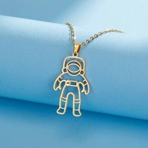 Macro shot of gold-plated astronaut cutout pendant with fine chain on blue background