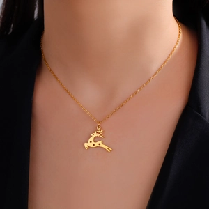 Primer plano de collar con colgante de reno dorado usado sobre una chaqueta negra