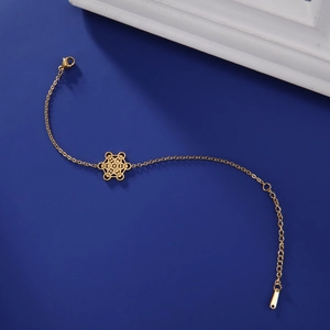 Vue macro du bracelet en acier doré avec pendentif géométrique Métatron sur fond bleu