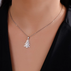 Primer plano de un collar con colgante de árbol de Navidad plateado con grabados finos