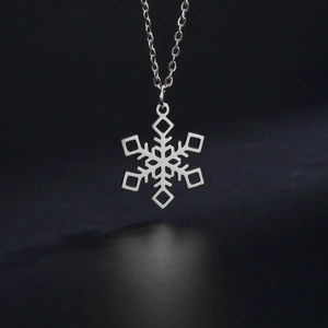 Polished silver snowflake pendant necklace in stainless steel on dark textured background