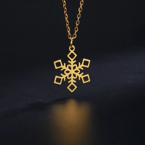 Detailed view of a golden snowflake pendant necklace with intricate geometric cutouts
