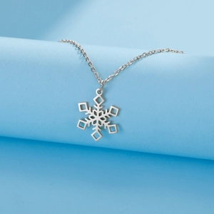 Macro shot of silver stainless steel snowflake pendant necklace with delicate chain links