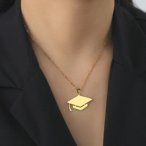 Collana dorata con ciondolo a tocco accademico su una modella in abito elegante