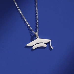 Polished silver stainless steel graduation cap pendant necklace on a blue background