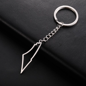 Detail shot of hollow mountain map pendant keychain on black leather background
