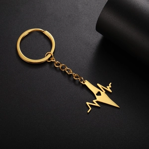 Detailed close-up of golden stainless steel keychain with heart pulse wave and cutout heart