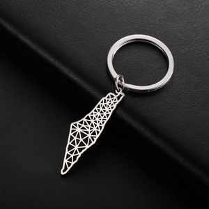 Macro view of silver geometric map outline keychain on black leather background