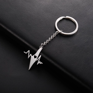 Detail of stainless steel heartbeat keychain with heart cut-out on black leather background