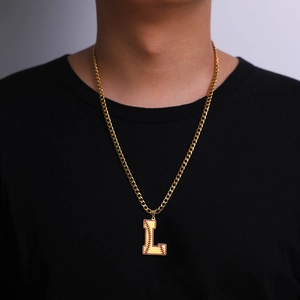 Détail du collier chaîne cubaine dorée avec pendentif lettre L au motif de baseball
