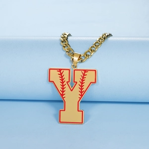 Gros plan d'un collier chaîne cubaine dorée avec pendentif lettre Y et détails baseball