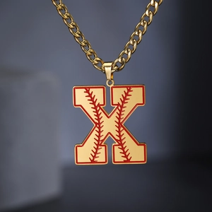 Gros plan d'une chaîne cubaine dorée avec pendentif lettre X motif baseball