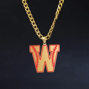 Gros plan sur chaîne cubaine dorée avec pendentif lettre W et détails de couture baseball