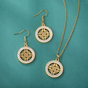 Detailed view of gold Celtic knot jewelry set with sparkling rhinestones on green background