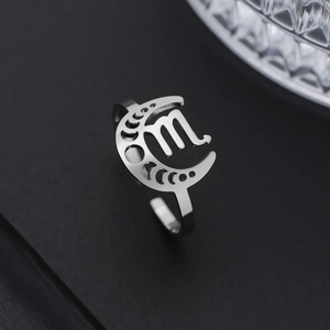 Macro d'une bague lune Scorpion en acier inoxydable argenté sur fond de prisme