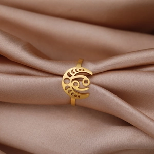Macro d'une bague croissant de lune dorée avec texture spirale sur satin champagne
