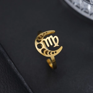 Gros plan d'une bague dorée signe Vierge avec motif lune sur fond de cuir noir