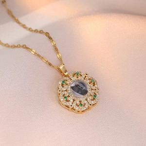 Vintage flower pendant necklace in gold with green emerald-like stones and zircon