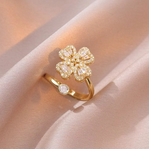 Dettaglio anello a quadrifoglio con zirconi su elegante tessuto di raso champagne