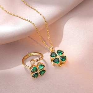 Elegante conjunto de collar y anillo de oro con tréboles de circón verde en seda rosa
