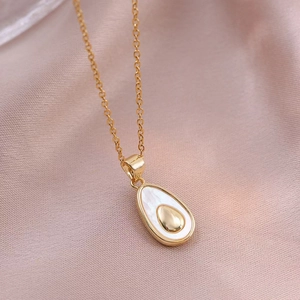 Elegante collana dorata a goccia con inserto in conchiglia su sfondo di raso rosa chiaro