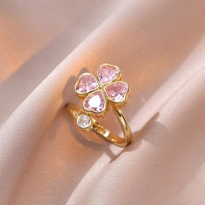 Detalle del colgante de flor giratoria con circonitas rosas de corazón en anillo de oro