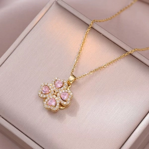 Vista macro della collana a quadrifoglio dorata con cristalli a cuore rosa e pavé