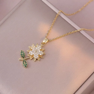 Collana girasole dorata con zirconi bianchi e verdi brillanti su superficie morbida