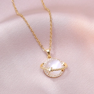 Minimalist planet pendant necklace with cat's eye stone and star detail on pink silk