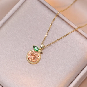 Collar de limón dorado con cristales micro pavé sobre joyero de satén rosa