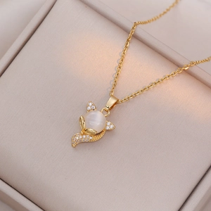 Macro d'un pendentif renard doré avec œil de chat et diamants dans un coffret à bijoux