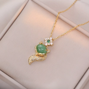 Détail du collier renard avec pierre verte et pavé de diamants dans un coffret beige