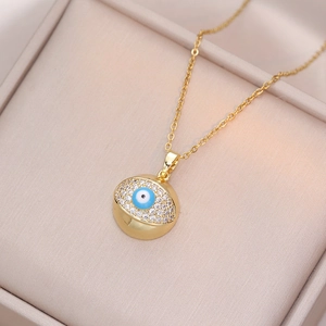 Goldene Titan-Halskette mit Evil Eye Anhänger und Zirkonia auf beige Hintergrund