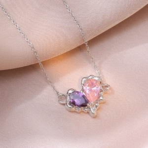 Irregular heart necklace with pink and purple pear-shaped zircons on silk background