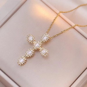 Vue détaillée du pendentif croix dorée orné de zircons étincelants de taille ovale