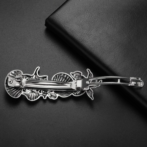 Detailed view of vintage silver starfish hair clip with spring fastener on leather