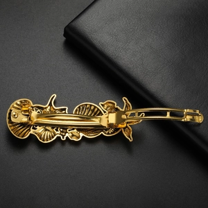 Detailed close-up of a vintage golden starfish and seashell metal spring hair clip
