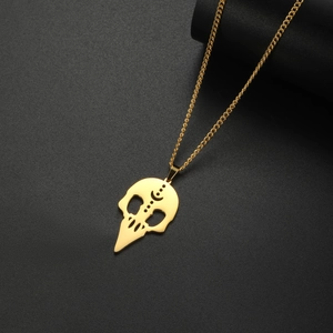 Primer plano del colgante de calavera de pájaro dorado con grabado lunar y estilo gótico