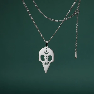 Primer plano del colgante de calavera de pájaro calada con grabado en cadena de acero