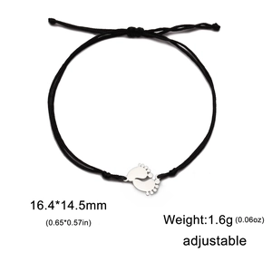 Detail view of adjustable black rope bracelet with stainless steel twin feet pendants