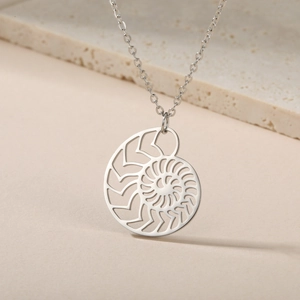 Dettaglio macro della collana con ciondolo a spirale di nautilus in acciaio inossidabile